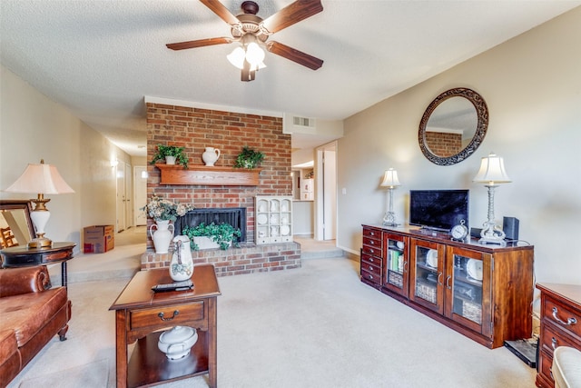 carpeted living room with ceiling fan, a textured ceiling, and a brick fireplace