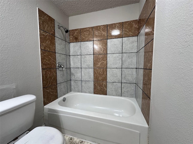 bathroom with tiled shower / bath, a textured ceiling, and toilet