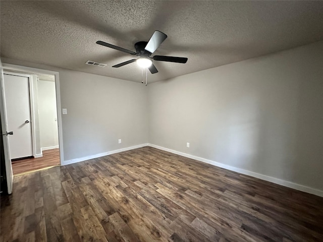 empty room with a textured ceiling, dark hardwood / wood-style flooring, and ceiling fan