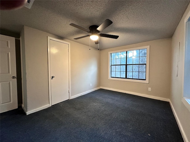 unfurnished bedroom featuring dark colored carpet, a textured ceiling, and ceiling fan