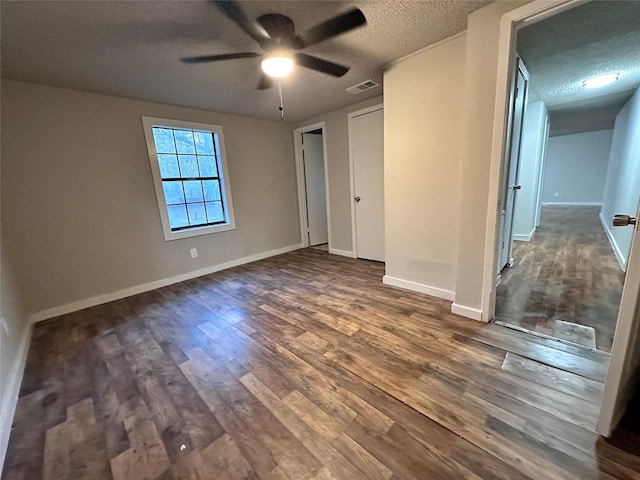 708 Ellington St, Atlanta, TX 75551 - unfurnished bedroom featuring a textured ceiling, baseboards, visible vents, ceiling fan, and dark wood-type flooring