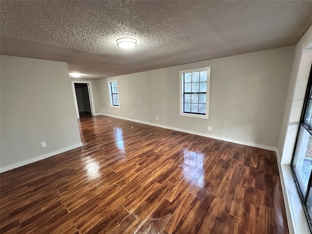 empty room featuring dark hardwood / wood-style flooring and a textured ceiling