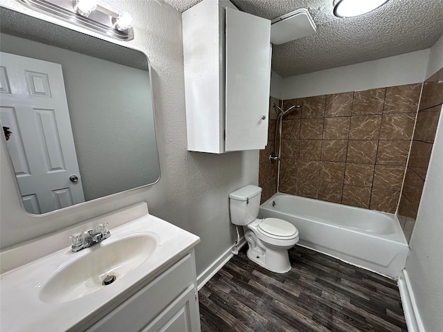 708 Ellington St, Atlanta, TX 75551 - bathroom with bathing tub / shower combination, wood finished floors, toilet, vanity, and a textured ceiling