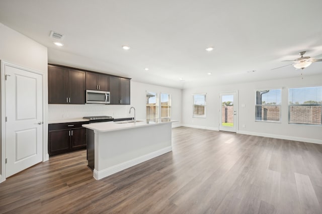 kitchen featuring appliances with stainless steel finishes, dark brown cabinets, dark hardwood / wood-style flooring, and sink