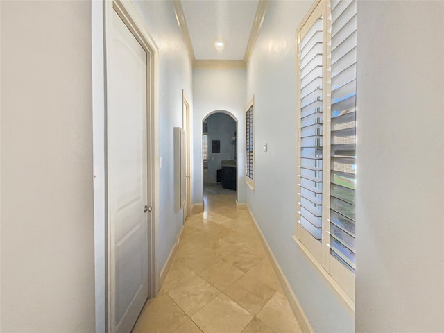 corridor featuring light tile patterned floors and crown molding