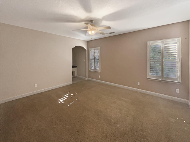 unfurnished room with ceiling fan and carpet