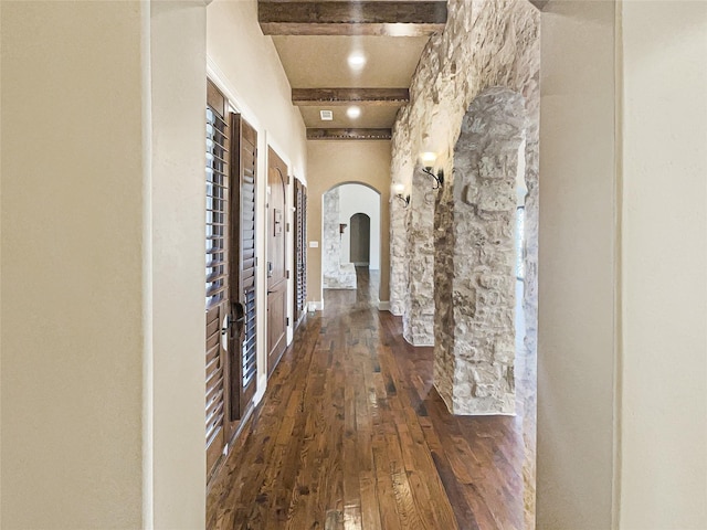 hallway featuring dark hardwood / wood-style flooring and beam ceiling