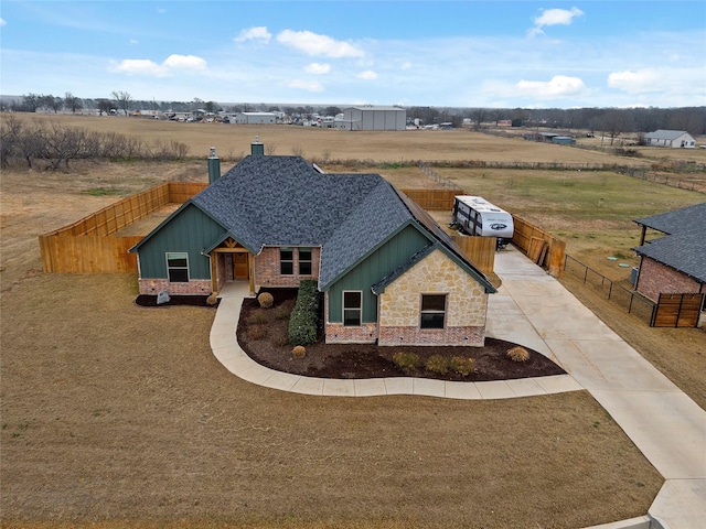 view of front of home featuring a shingled roof, board and batten siding, fence, and driveway