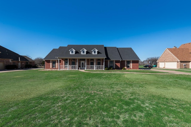 view of front of house with a front yard, a porch, and brick siding