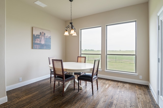 dining room with dark hardwood / wood-style flooring and a chandelier