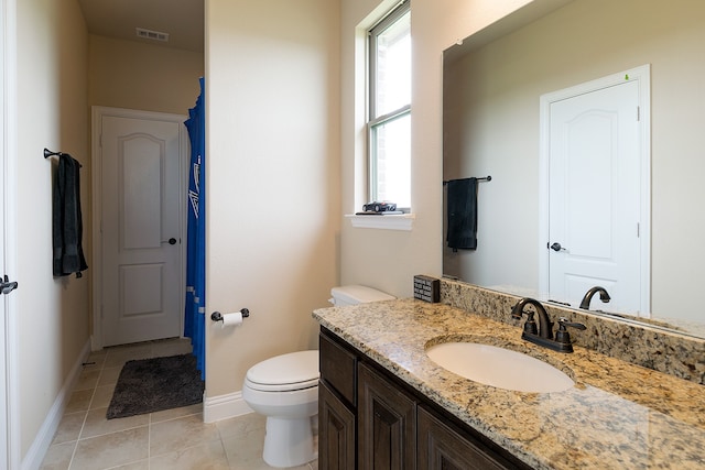 bathroom with toilet, tile patterned floors, and vanity