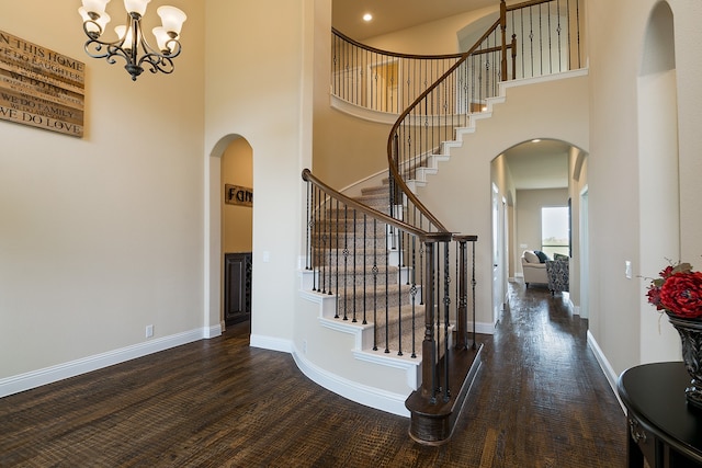 staircase featuring a high ceiling, a chandelier, and hardwood / wood-style flooring