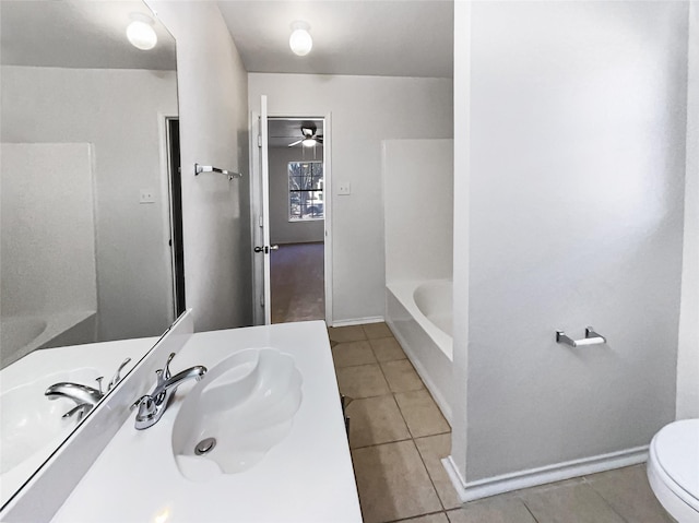 bathroom featuring toilet, tile patterned flooring, a washtub, and vanity