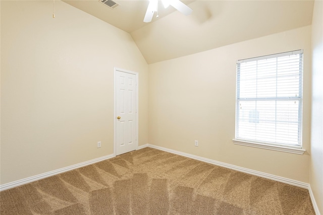 carpeted spare room featuring ceiling fan, lofted ceiling, and a wealth of natural light