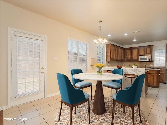 dining area with an inviting chandelier and light tile patterned floors