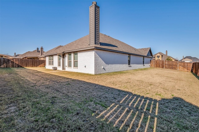 rear view of house featuring a yard