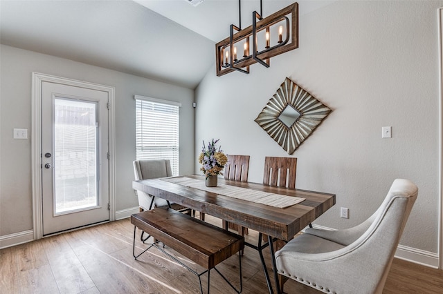 dining area featuring a chandelier, hardwood / wood-style flooring, and lofted ceiling