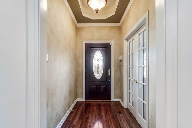 doorway to outside with dark wood-type flooring, ornamental molding, and a tray ceiling