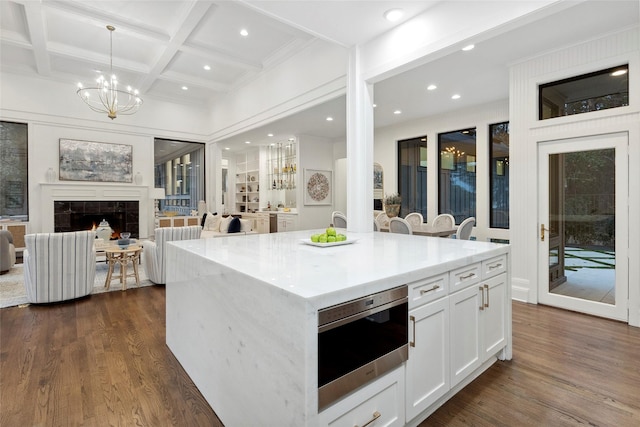 kitchen featuring coffered ceiling, beamed ceiling, white cabinets, a kitchen island, and hanging light fixtures