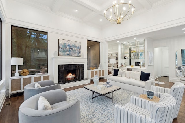 living room with coffered ceiling, beamed ceiling, a notable chandelier, wood-type flooring, and a fireplace