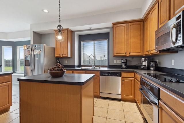 kitchen featuring stainless steel appliances, a healthy amount of sunlight, sink, a center island, and light tile patterned flooring