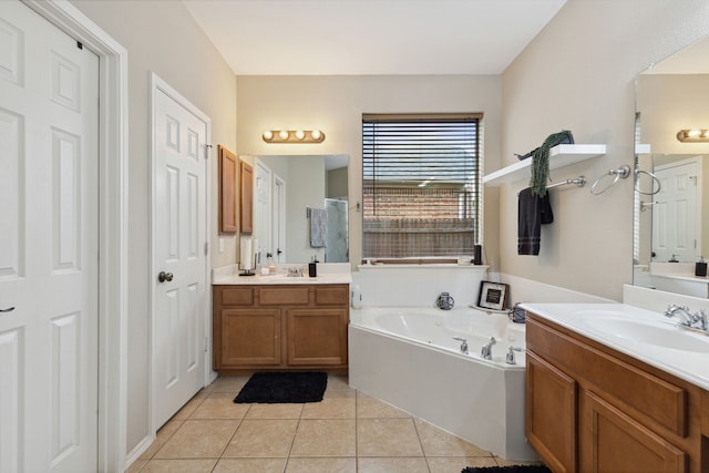 bathroom with tile patterned floors, a tub, and vanity