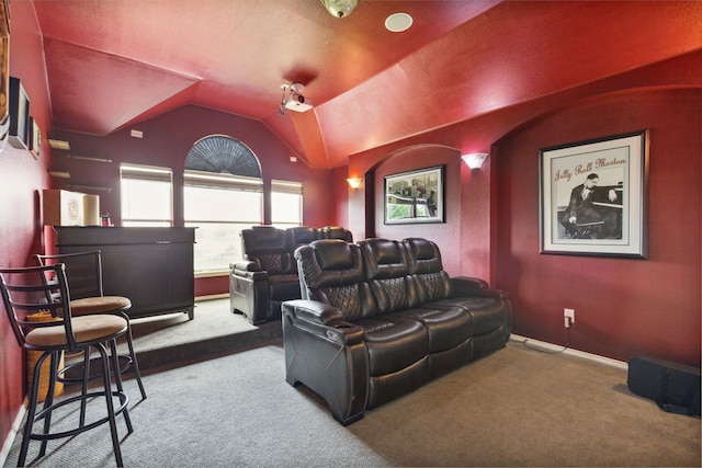 home theater featuring carpet floors, indoor bar, and vaulted ceiling