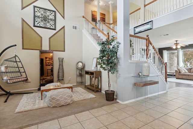 staircase featuring tile patterned flooring, a high ceiling, and ceiling fan