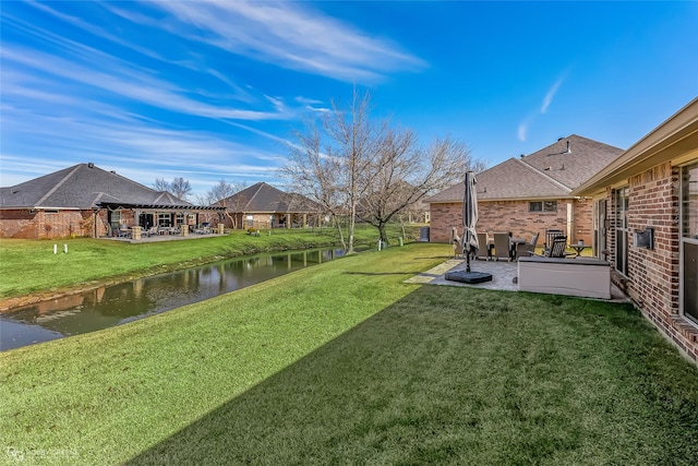 view of yard with a pergola, a water view, and a patio area