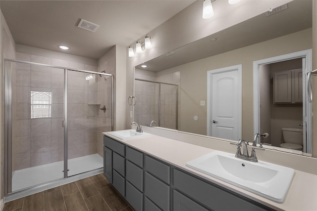 bathroom featuring vanity, toilet, and an enclosed shower