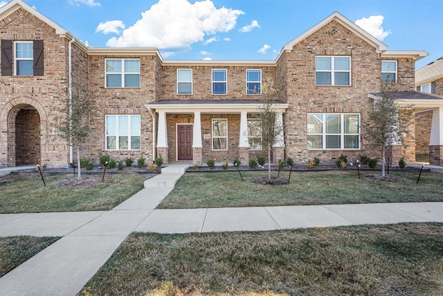 view of front of home with covered porch and a front lawn