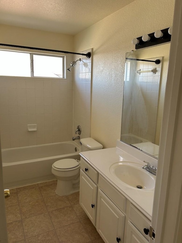 full bathroom featuring tiled shower / bath combo, toilet, a textured ceiling, and vanity