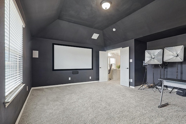 home theater room featuring carpet and lofted ceiling