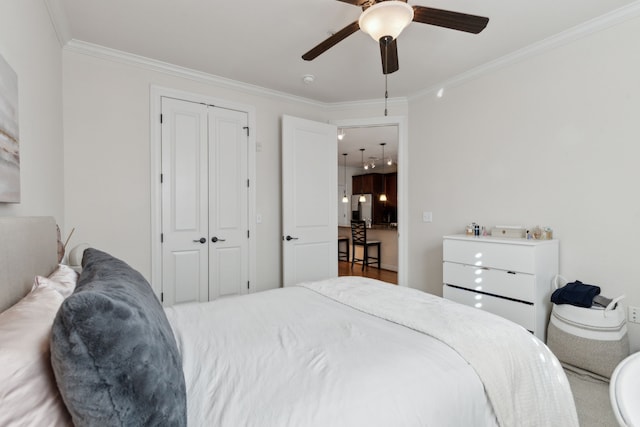 bedroom with crown molding, a ceiling fan, a closet, and freestanding refrigerator