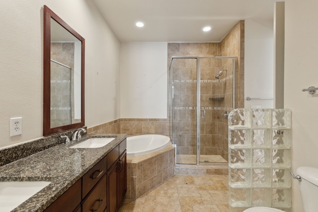 bathroom featuring a sink, a garden tub, double vanity, and a shower stall