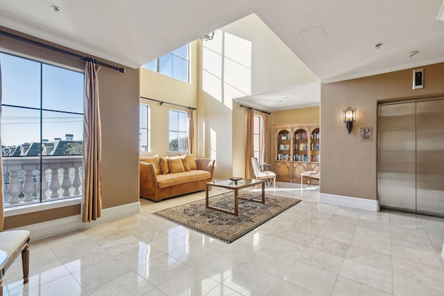 living room with elevator, baseboards, and a towering ceiling