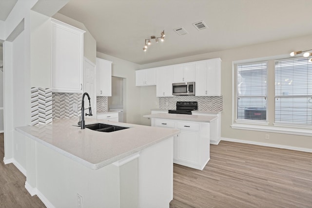 kitchen featuring sink, white cabinetry, black range with electric stovetop, and a kitchen island