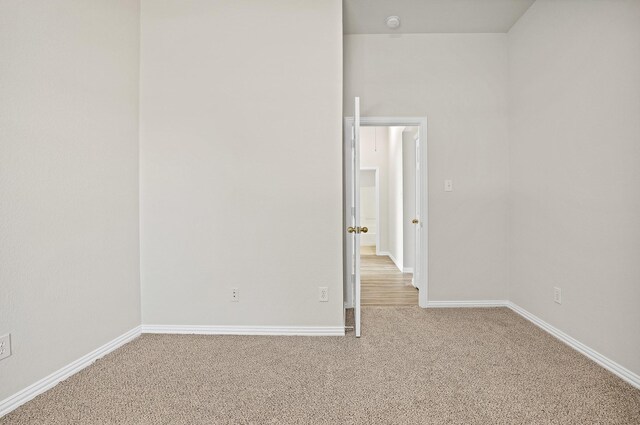 empty room with light carpet and vaulted ceiling