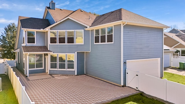 rear view of house featuring a patio area and a garage