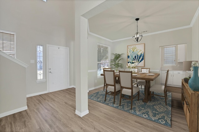 dining room with a wealth of natural light, light hardwood / wood-style flooring, and a notable chandelier