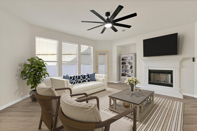 unfurnished living room with light wood-type flooring, ceiling fan with notable chandelier, plenty of natural light, and sink