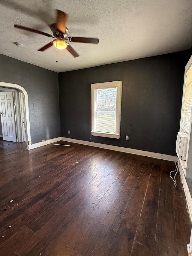 empty room featuring a textured ceiling, ceiling fan, and dark hardwood / wood-style floors