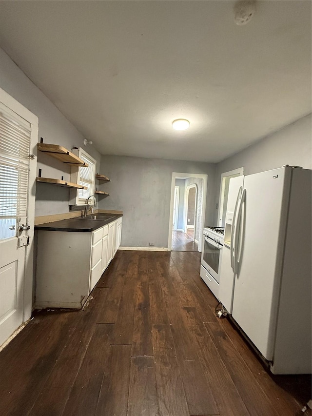 kitchen featuring white appliances, sink, dark hardwood / wood-style floors, and white cabinetry