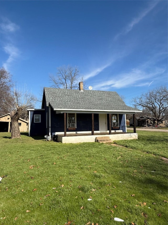 rear view of house featuring a lawn