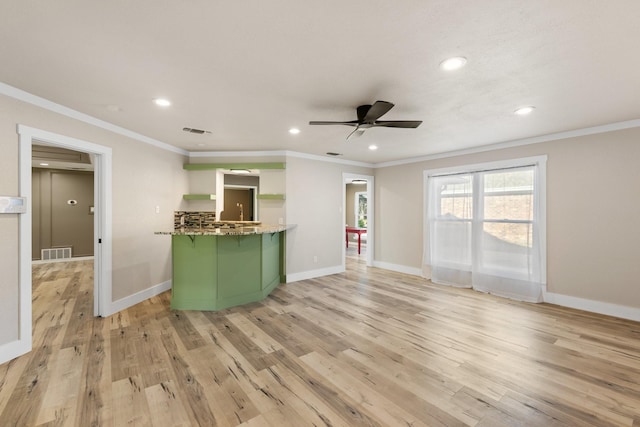 kitchen with ceiling fan, light wood-type flooring, green cabinetry, and ornamental molding