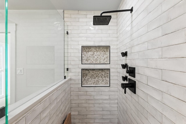 bathroom with a tile shower and ornamental molding