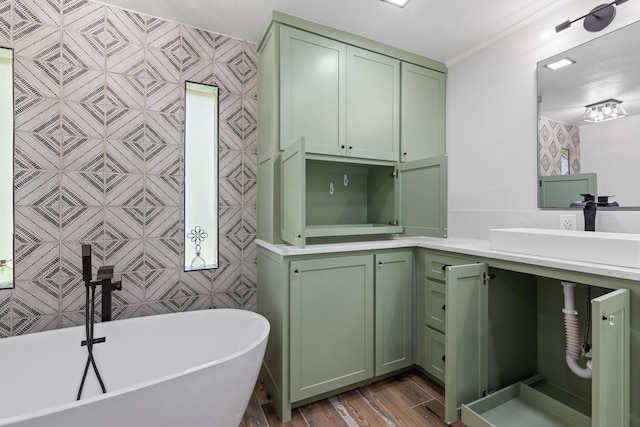 bathroom with a tub, vanity, and wood-type flooring