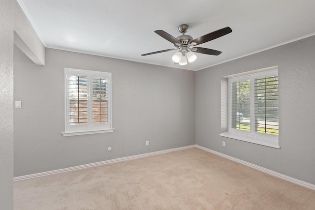 carpeted empty room with ceiling fan and ornamental molding