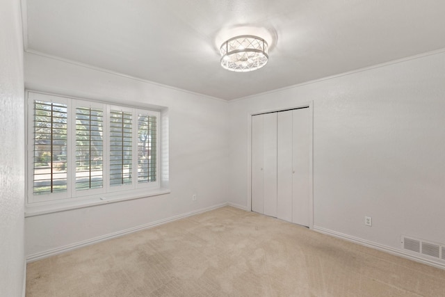 unfurnished bedroom featuring light carpet, a closet, multiple windows, and ornamental molding