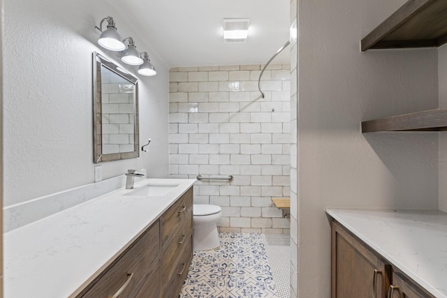 bathroom featuring vanity, a shower, tile walls, tile patterned flooring, and toilet